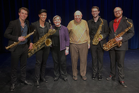 Philippa and Chuck Webb, center, with an MSU saxophone quartet that performed at Beacon Hill in Grand Rapids, dark stage.