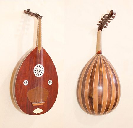Front and back views of a stringed instrument known as an Oudipedia. Made of wood with a dark and light wood striped design on the back.