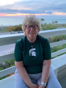 Martha Scharchburg smiling in front of a sunset