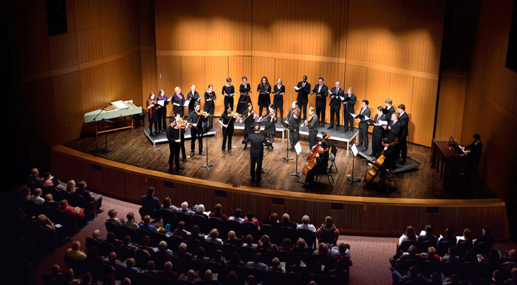 View from high on right side looking at choir singing on a stage