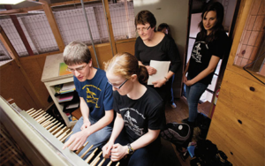 Four people at carillon keyboard during a lesson