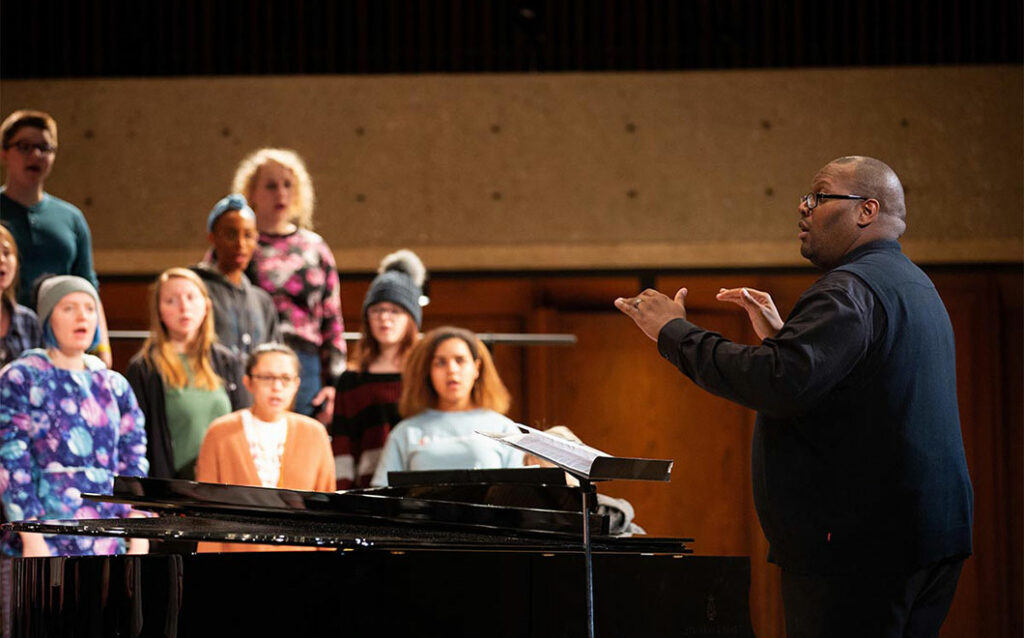 Photo taken from a side profile of Derrick Fox conducting 