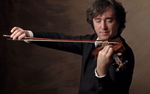 Portrait of violinist Dmitri Berlinsky, intently focusing on violin while playing