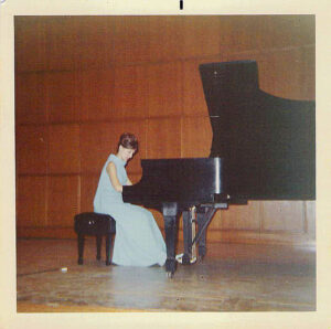 Old photo of Barbara Dixon on piano