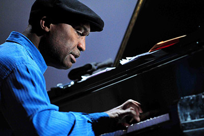 Man in blue shirt and cap plays an organ