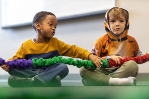 Two young boys sitting on the ground 