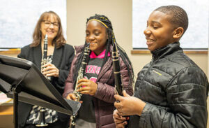 Young students smiling while holding clarinets 