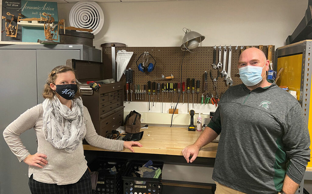 Two people with masks posed in the piano shop