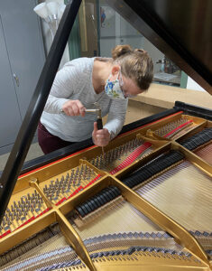 Photo of a woman fixing a piano