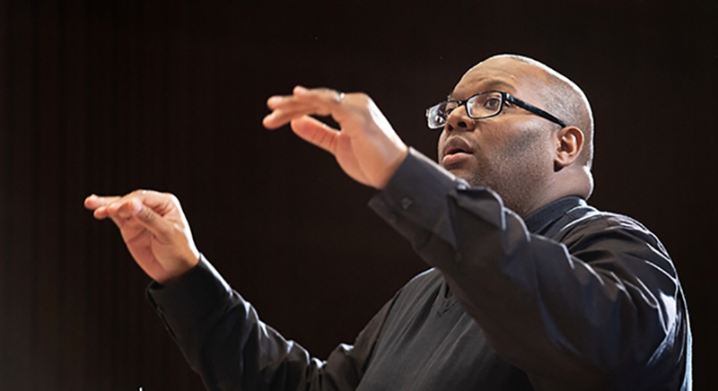 conductor directs choir with hands