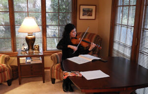 Daniela Diaz sitting down playing violin