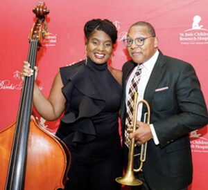 woman with upright bass with man holding trumpet