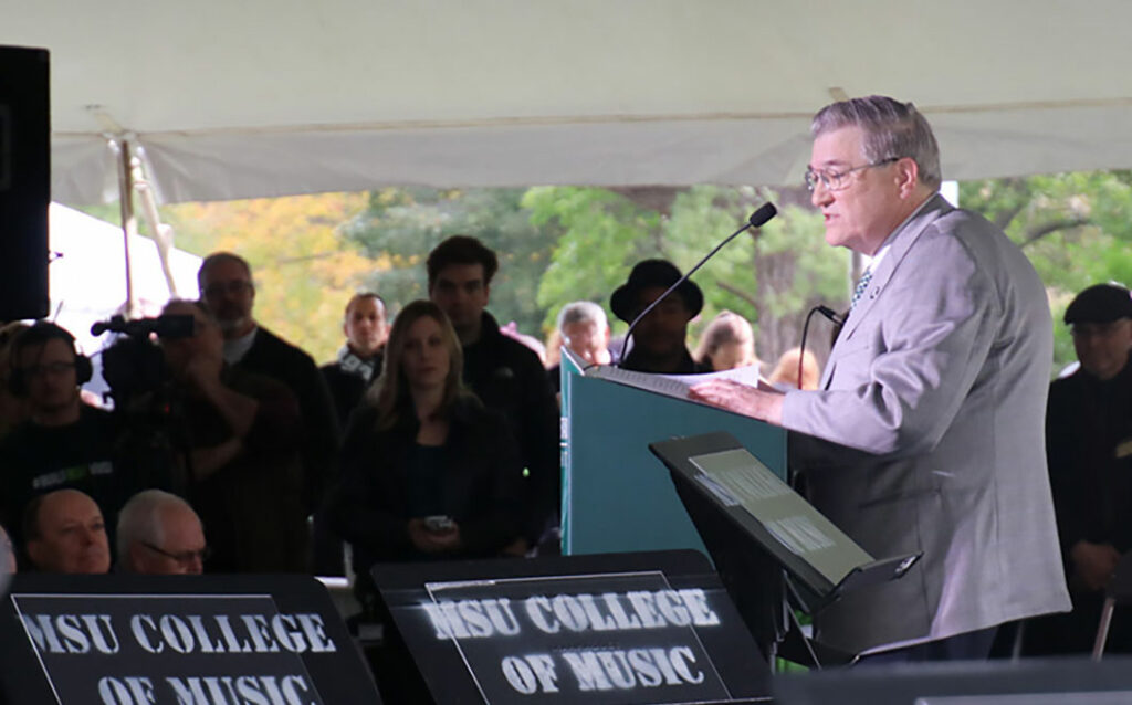 Dr. James Billman giving a speech on a podium