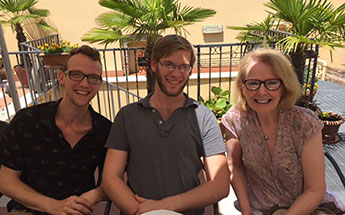 Photo of three people sitting outside