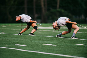 Two people doing a backbend on the field 