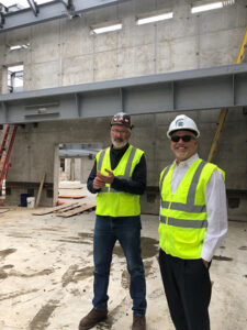 Two men smiling at a construction site 