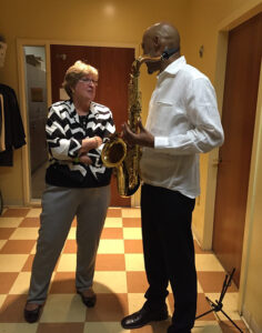 Martha Scharchburg talking to saxophone player 