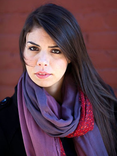 close up of woman with long, dark hair wearing a scarf with blue, violet and red colors