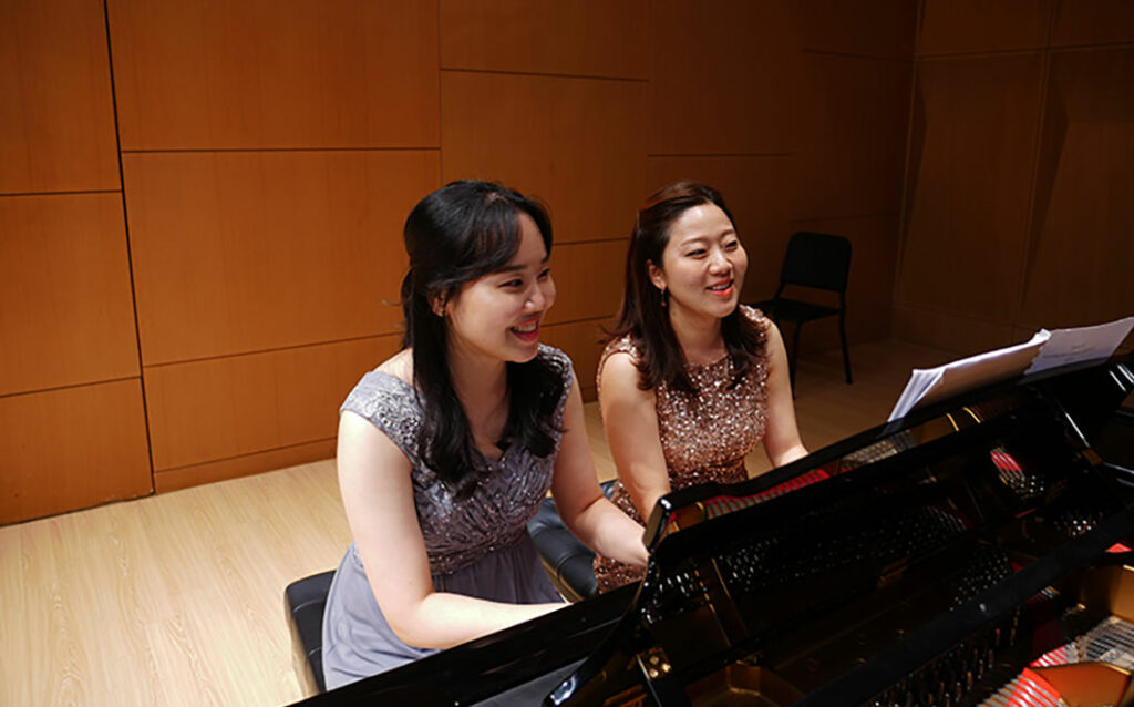 Two alumni on the piano