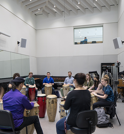 A group of students in a drum circle in Shalon Percussion Hall at Michigan State University College of Music.