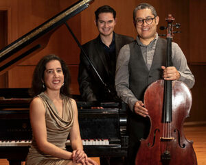 Photo of three musicians smiling by their instruments