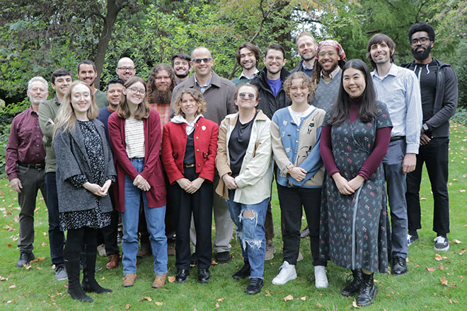 A posed gathering of Music Theory students with faculty in an outdoor setting with campus trees in the background