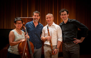 Group of people smiling and holding up their instruments 