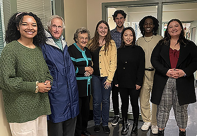 group photo of eight people standing and smiling