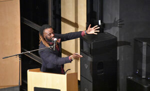 Omar Thomas speaking at a podium 