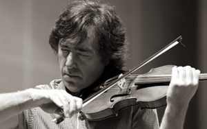 Black and white portrait photo of dmitri berlinsky performing on violin. Intently focused with concentration, eyes closed