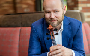 Elias Goldstein holding a viola. Headshot