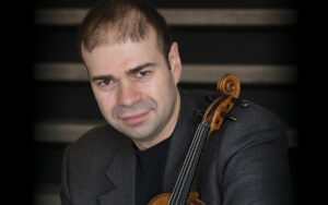 Headshot of Grigory Kalinovsky holding violin.