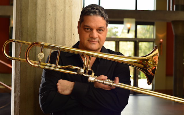 Domingo Pagluica holds his trombone with crossed arms