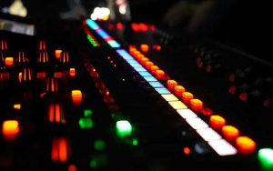 a mixing board with many buttons lit up