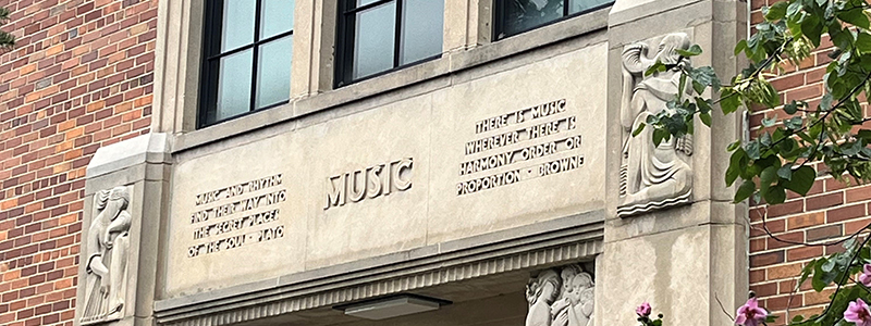 concrete entrance sign on red brick building. Words read MUSIC; music and rhythm find their way into the secret places of the soul - Plato; There is music wherever there is harmony, order or proportion p Browne