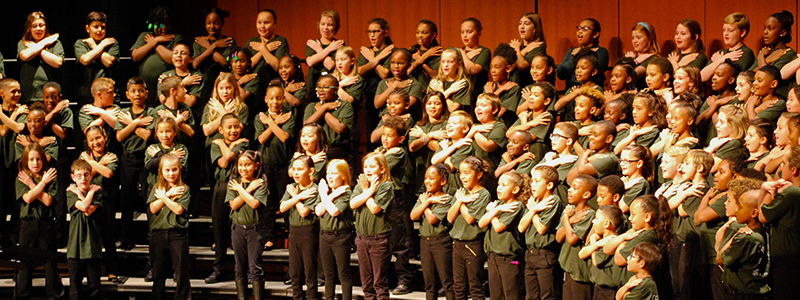 large choir of children performing on stage