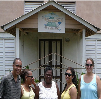 a group of five people standing outside a small church