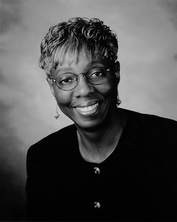 a person with short hair and glasses wearing a black shirt