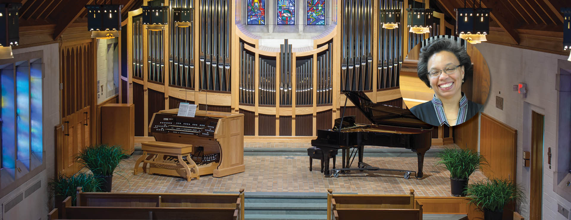 setting of the alumni memorial chapel stage with piano and organ instruments in the foreground, in the background are the pipes of the organ, and stained glass window at the top
