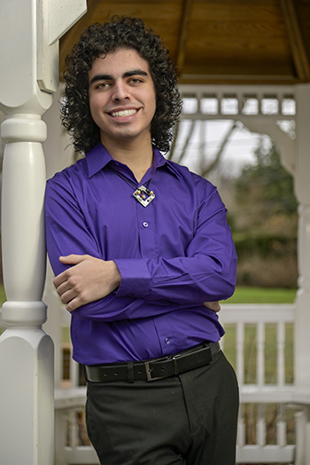 person in purple shirt leans on a pillar of a gazebo