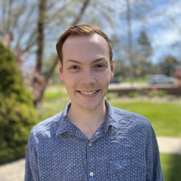 smiling person standing outside in a neighborhood