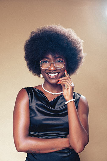 smiling person in black dress wearing glasses