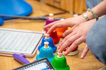 person's hands playing small colorful bells
