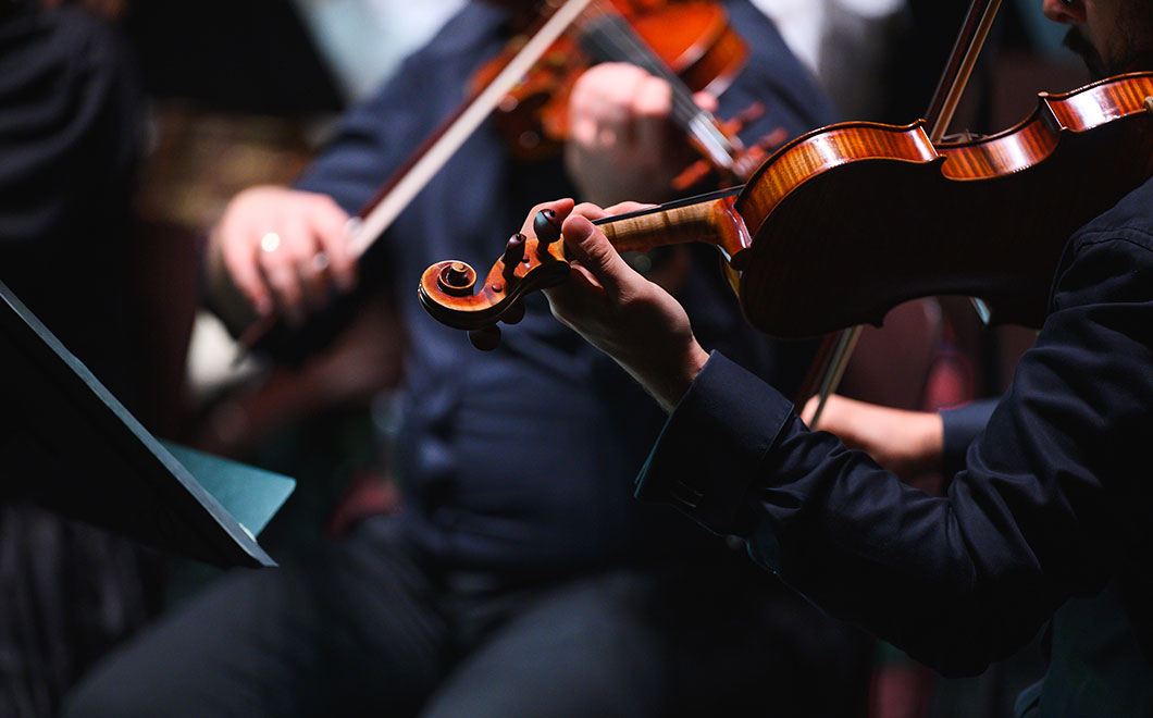 closeup of chamber musicians peforming, violin and viola, in formal concert attire