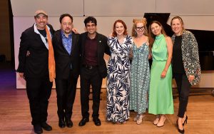 Members of the American Modern Ensemble pose together for a photo on a concert stage.