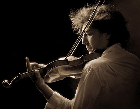 Portrait of violinist Dmitri Berlinsky, performing under dramatic lighting