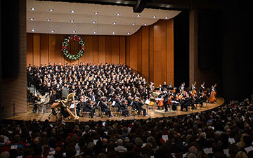 a choir and orchestra perform together on stage