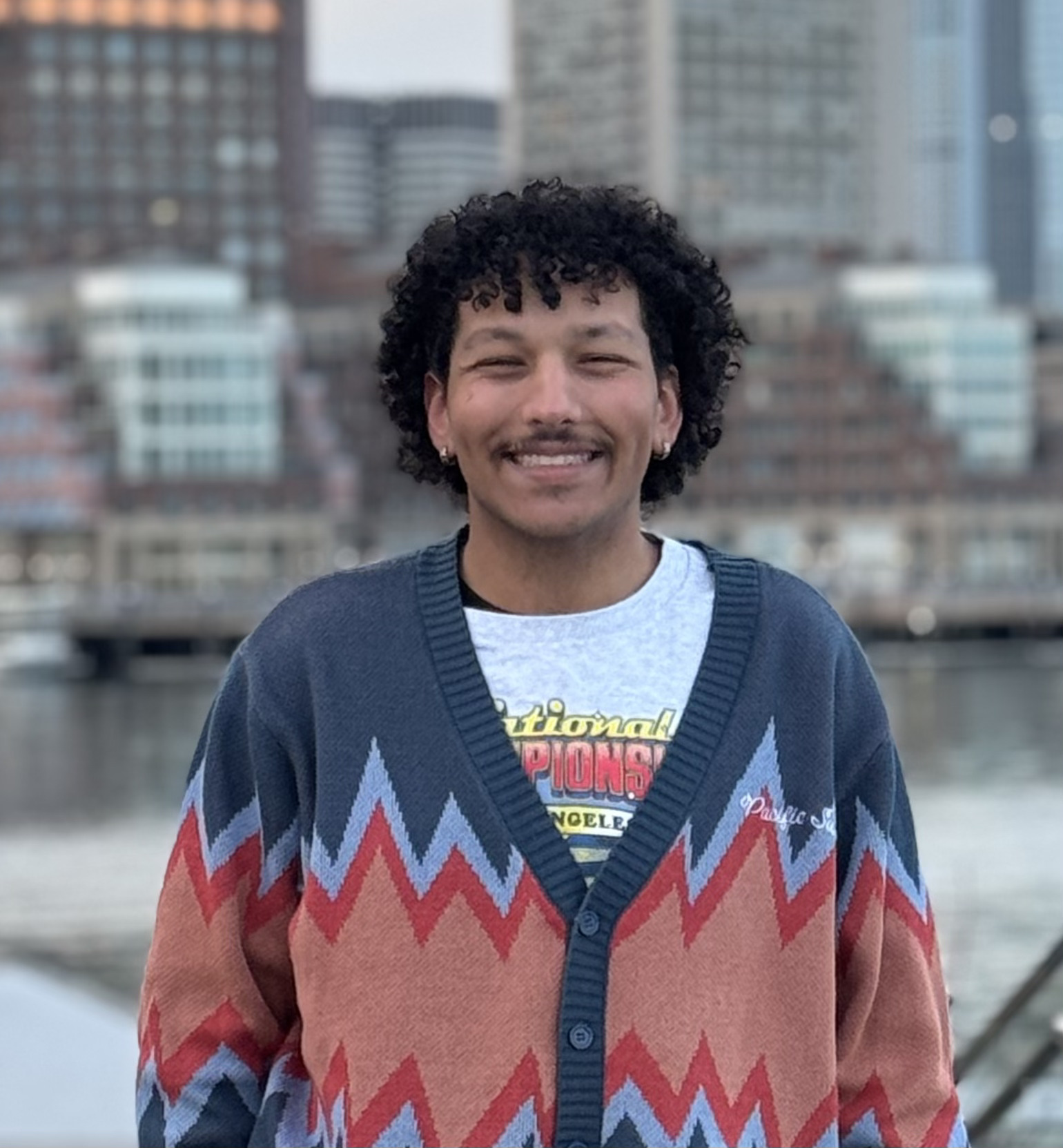 a man with curly hair smiles at the camera