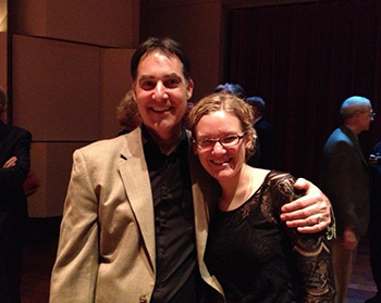 two people smiling and standing next to each other