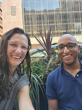 two smiling people outside of a building